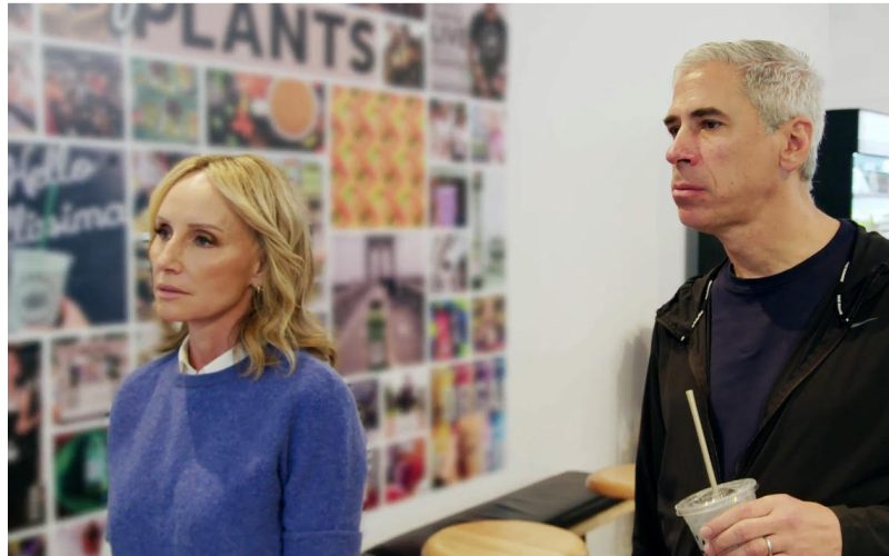 two people standing in front of a board of photos