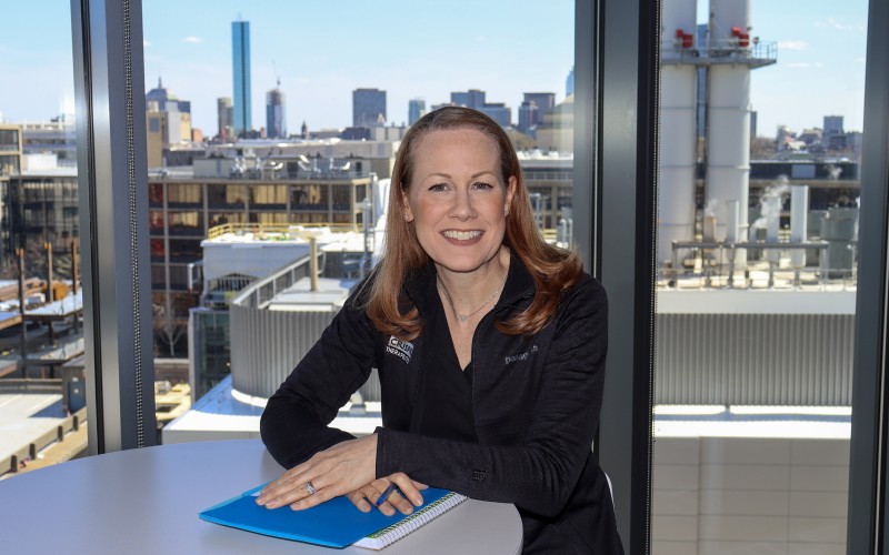 woman in an office with a city skyline behind her